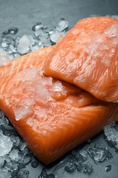 Fresh raw salmon with ice on black table, closeup
