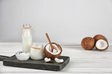 Composition with fresh coconut oil on white wooden table, space for text. Cooking ingredient