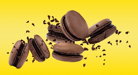 Image of Sweet delicious macarons flying on yellow background