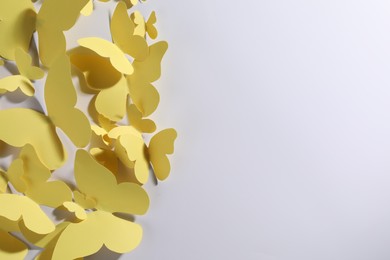 Yellow paper butterflies on white background, top view. Space for text