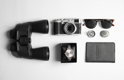 Photo of Flat lay composition with camera and binoculars on white background. Travel agency