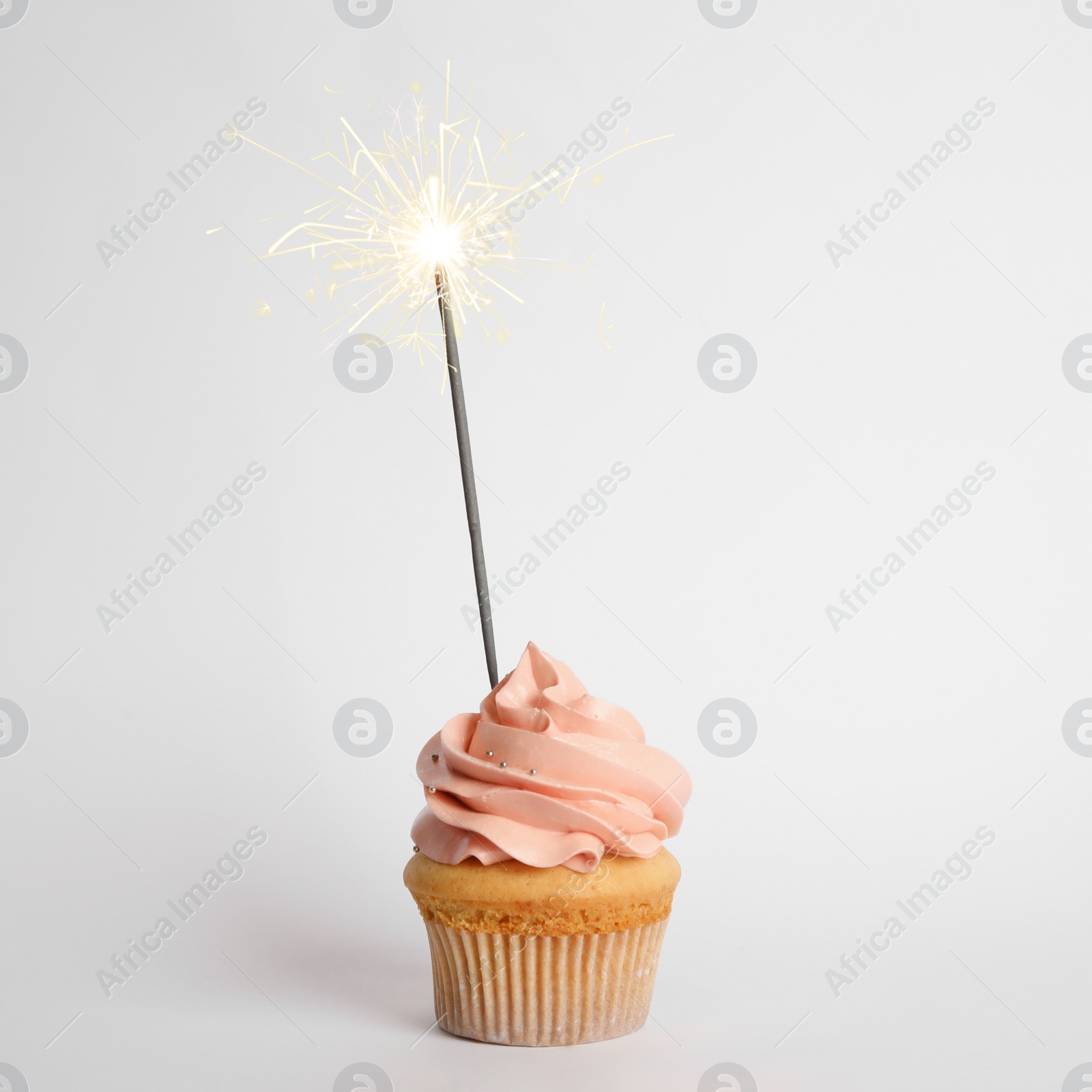 Image of Birthday cupcake with sparkler on white background