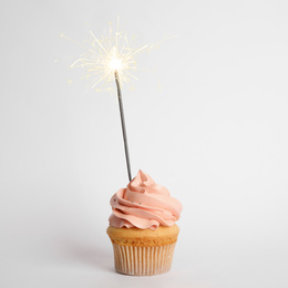 Birthday cupcake with sparkler on white background