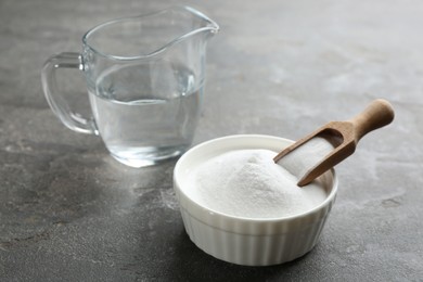 Photo of Baking soda in bowl on grey table