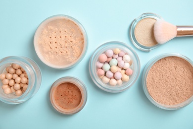 Photo of Flat lay composition with various makeup face powders on color background