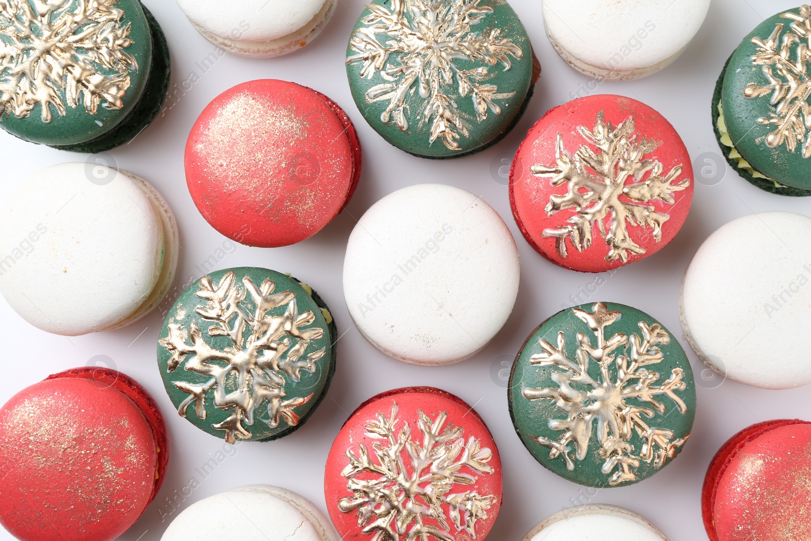 Photo of Beautifully decorated Christmas macarons on white background, top view