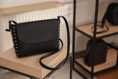 Photo of Elegant black bag on table in luxury boutique