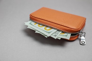 Photo of Stylish brown leather purse with dollar banknotes on light grey background. Space for text