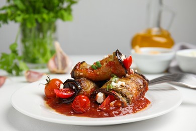 Tasty eggplant rolls served on white table, closeup