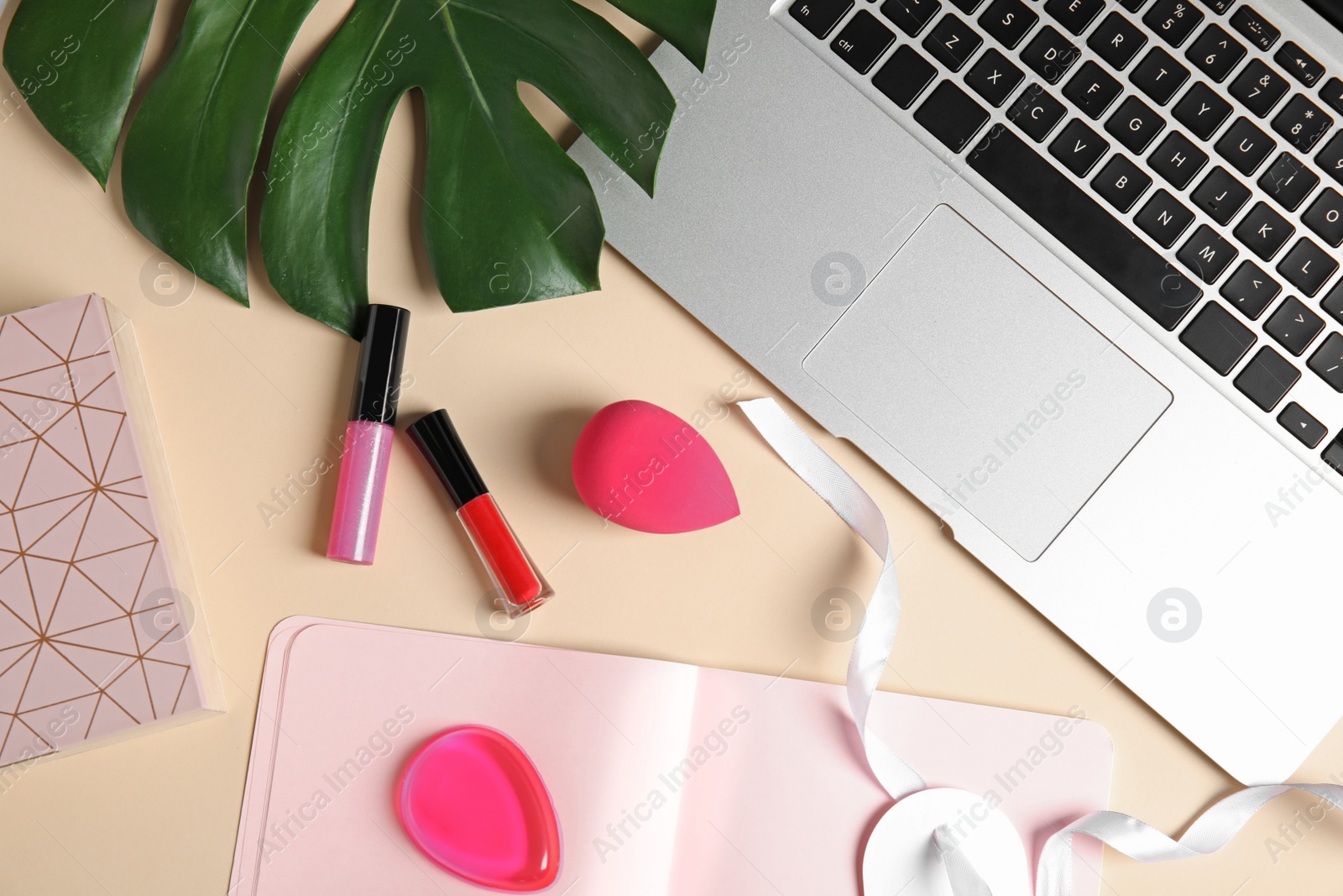 Photo of Flat lay composition with laptop and cosmetics on color background. Beauty blogger's workplace