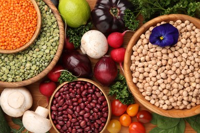 Photo of Different vegetables on wooden table, flat lay. Vegan diet