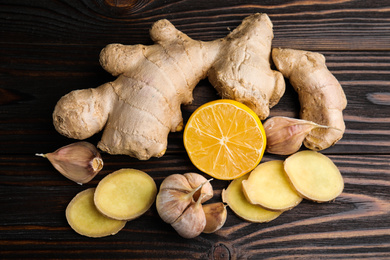 Photo of Fresh garlic and other natural cold remedies on wooden table, flat lay