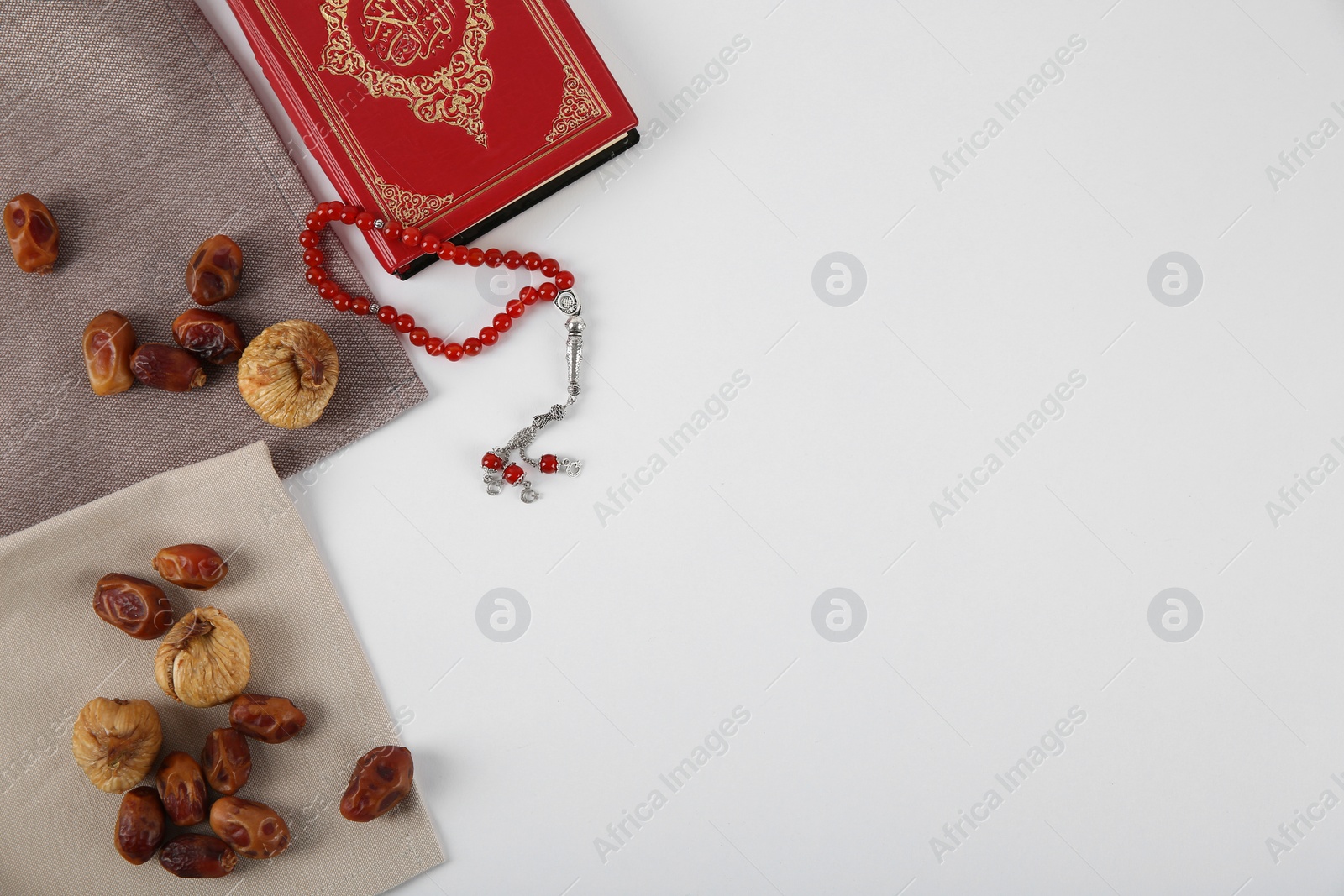 Photo of Flat lay composition with Koran, Muslim prayer beads and space for text on white background