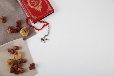 Flat lay composition with Koran, Muslim prayer beads and space for text on white background