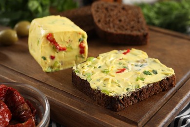 Photo of Tasty butter with green onion, chili pepper and rye bread on table, closeup