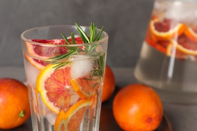 Photo of Delicious refreshing drink with sicilian orange and rosemary near fresh ingredients on table, closeup