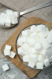 White sugar cubes in glass bowl on grey table, top view