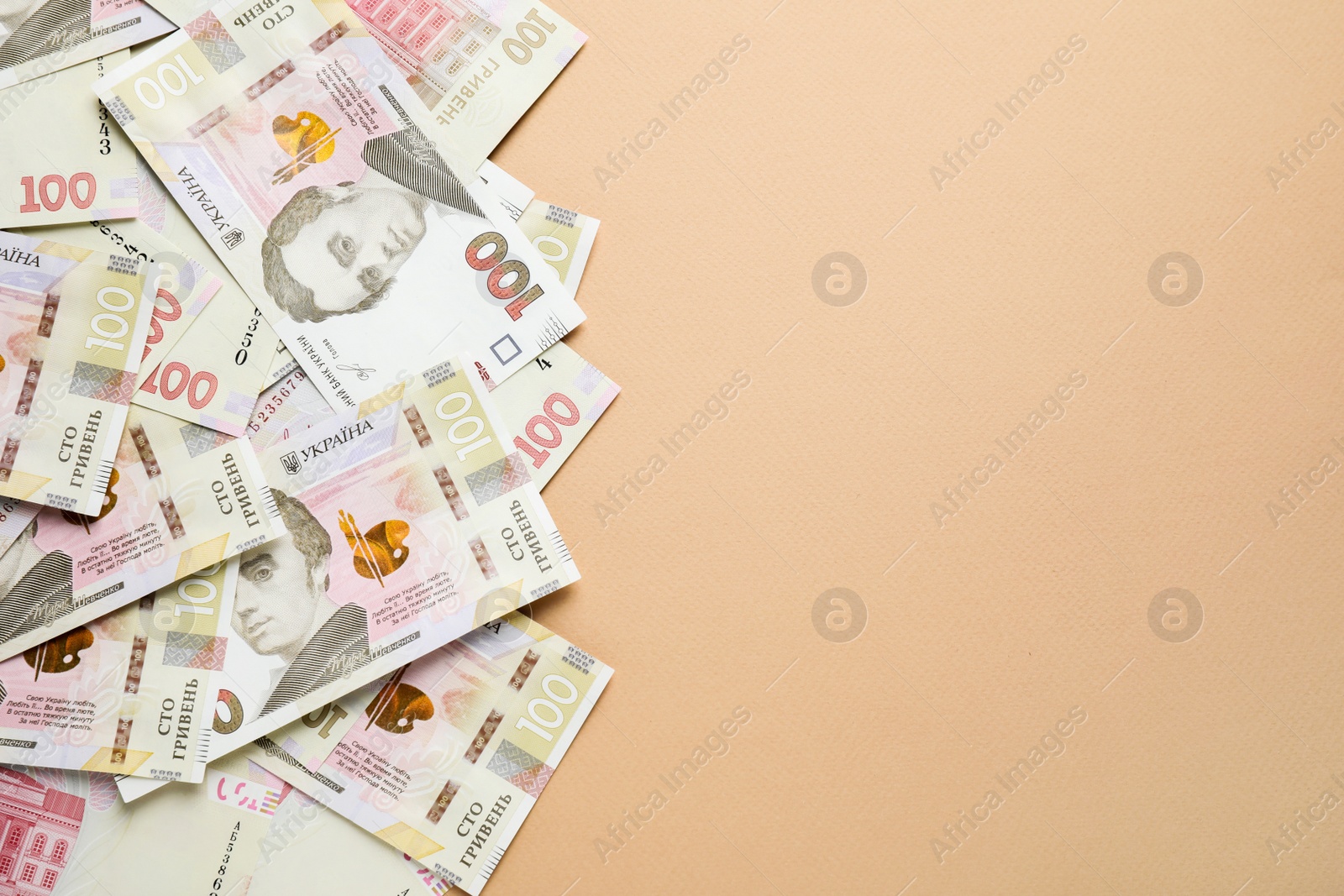 Photo of Ukrainian money on beige background, flat lay. Space for text