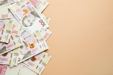Ukrainian money on beige background, flat lay. Space for text