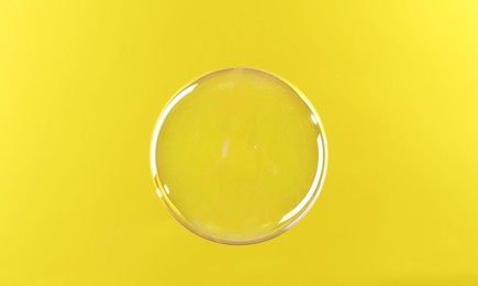 Photo of Beautiful transparent soap bubble on yellow background