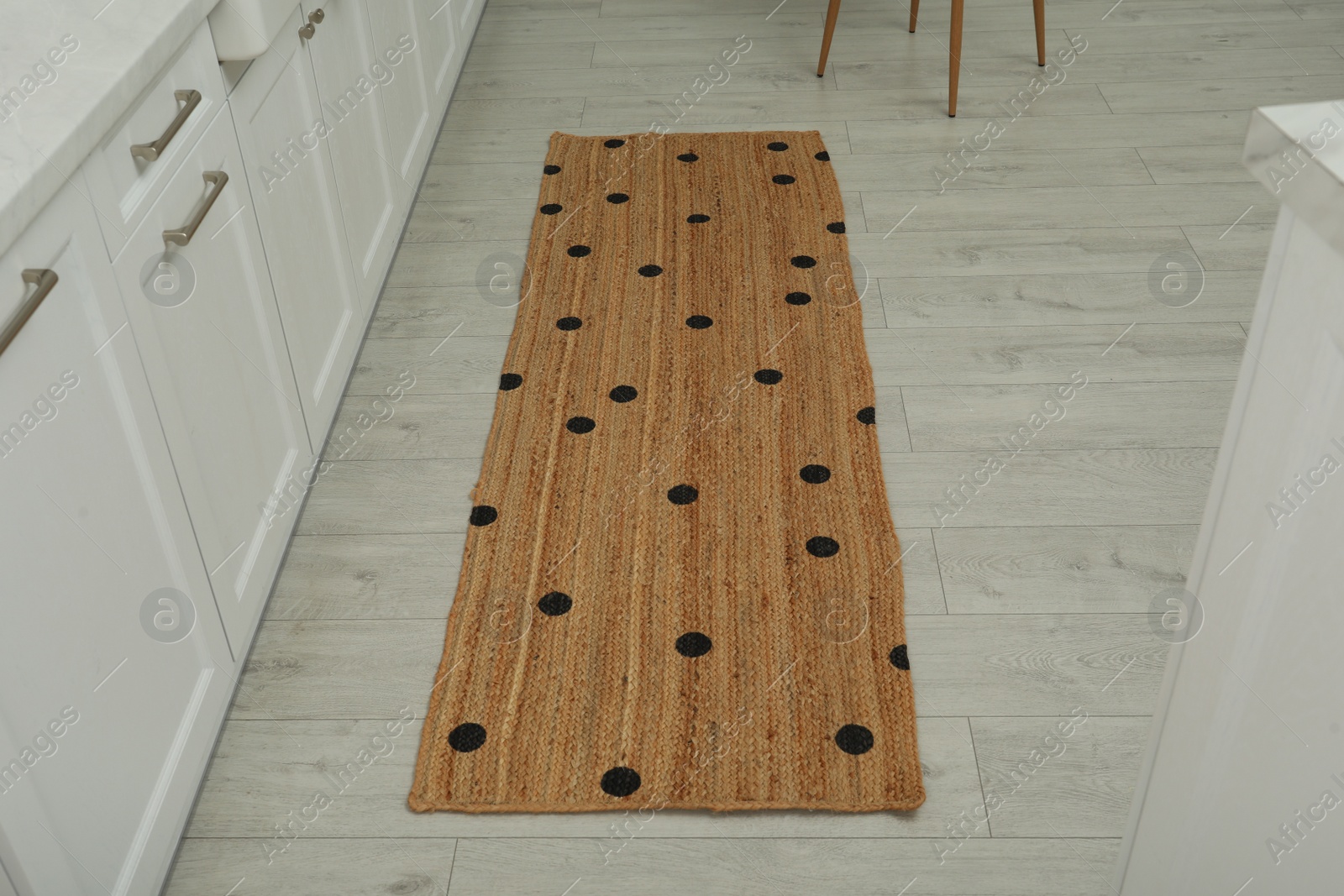 Photo of Stylish rug with dots on floor in kitchen