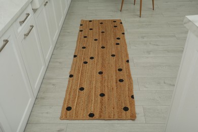Stylish rug with dots on floor in kitchen