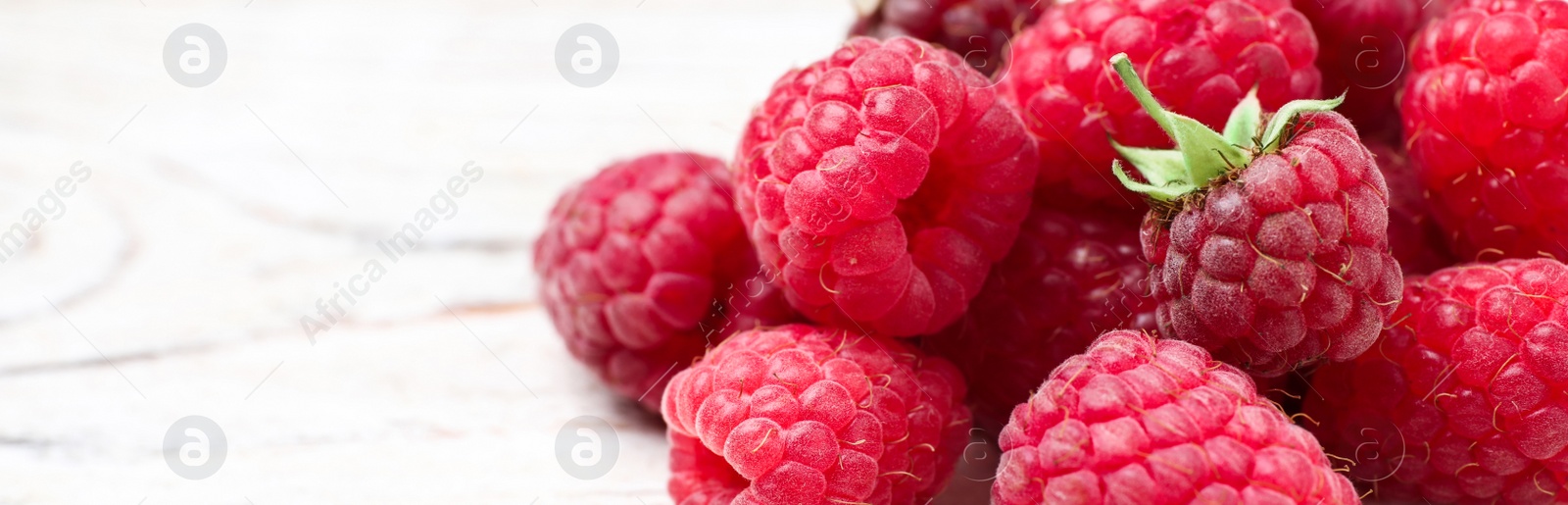 Photo of Delicious fresh ripe raspberries on white wooden table, closeup