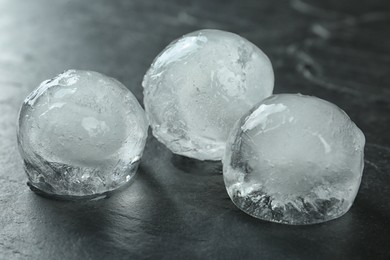 Photo of Frozen ice balls on black table, closeup