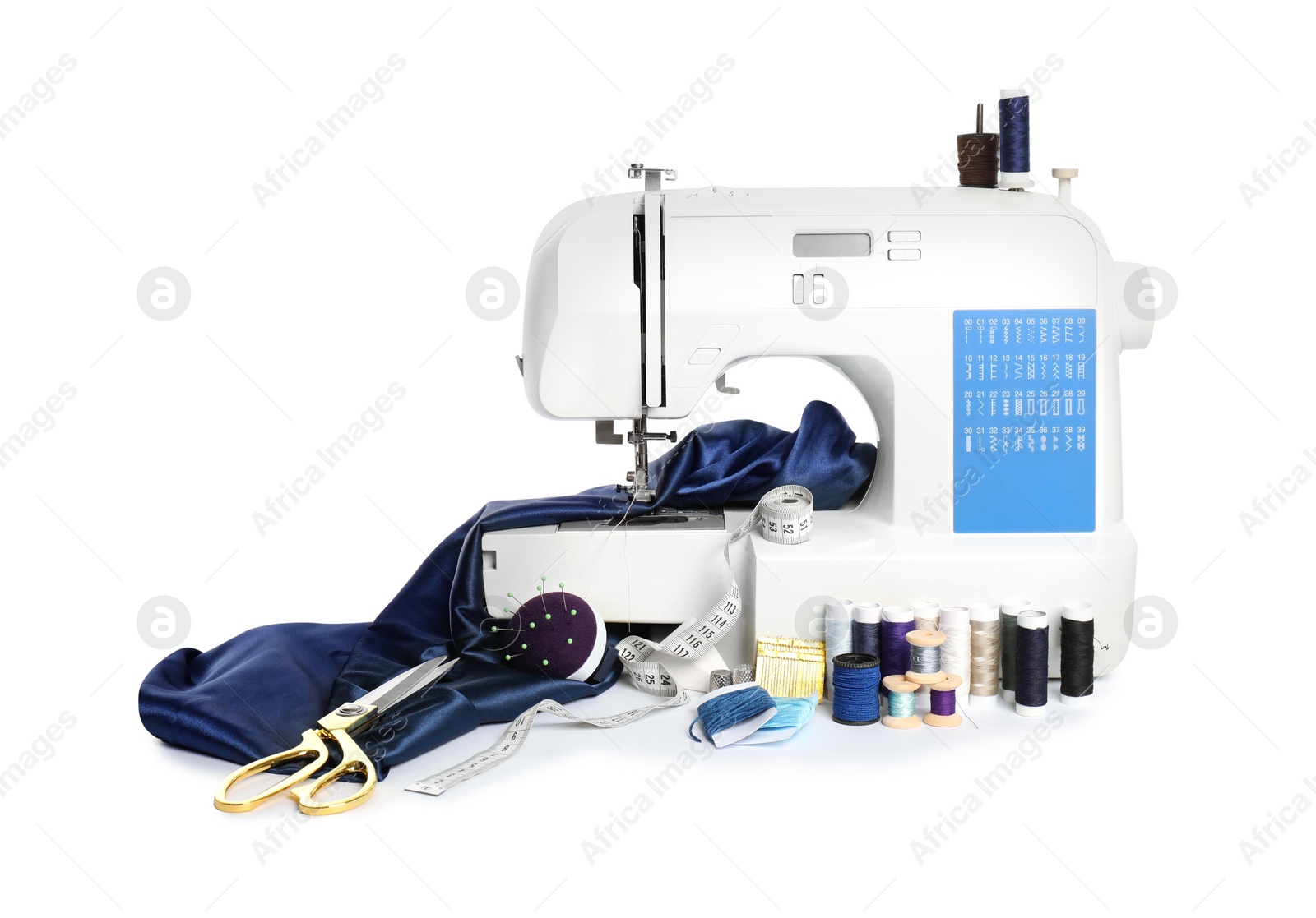 Photo of Modern sewing machine with blue cloth and craft accessories isolated on white