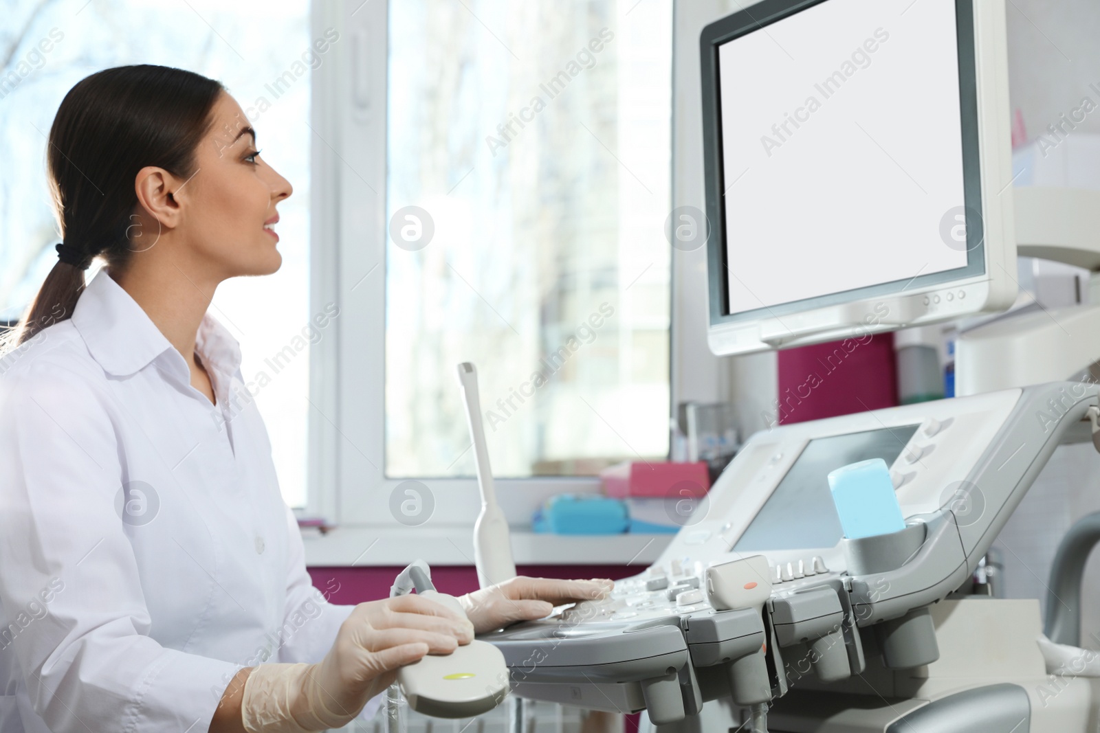 Photo of Sonographer using modern ultrasound machine in clinic