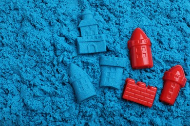 Toys on blue kinetic sand, flat lay
