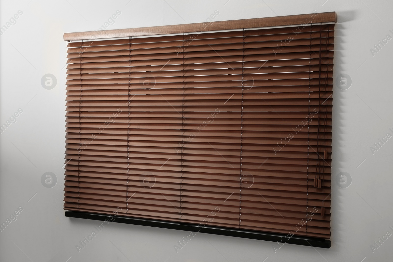 Photo of Modern window with closed stylish wooden blinds indoors. Space for text