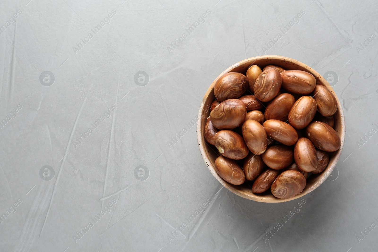Photo of Bowl of jackfruit seeds on light table, top view. Space for text