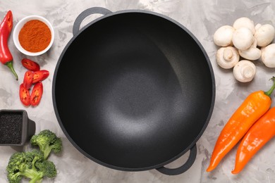 Photo of Wok and different products on grey textured table, flat lay