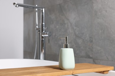 Bath accessory. Liquid soap dispenser on tub in bathroom