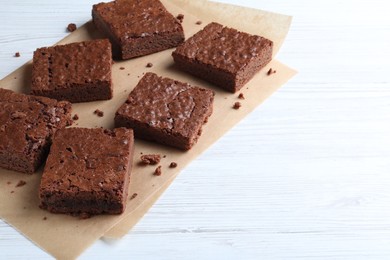 Delicious chocolate brownies on white wooden table. Space for text