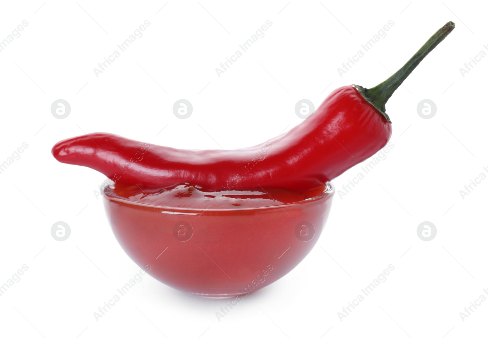 Photo of Glass bowl with red sauce and fresh chili pepper isolated on white