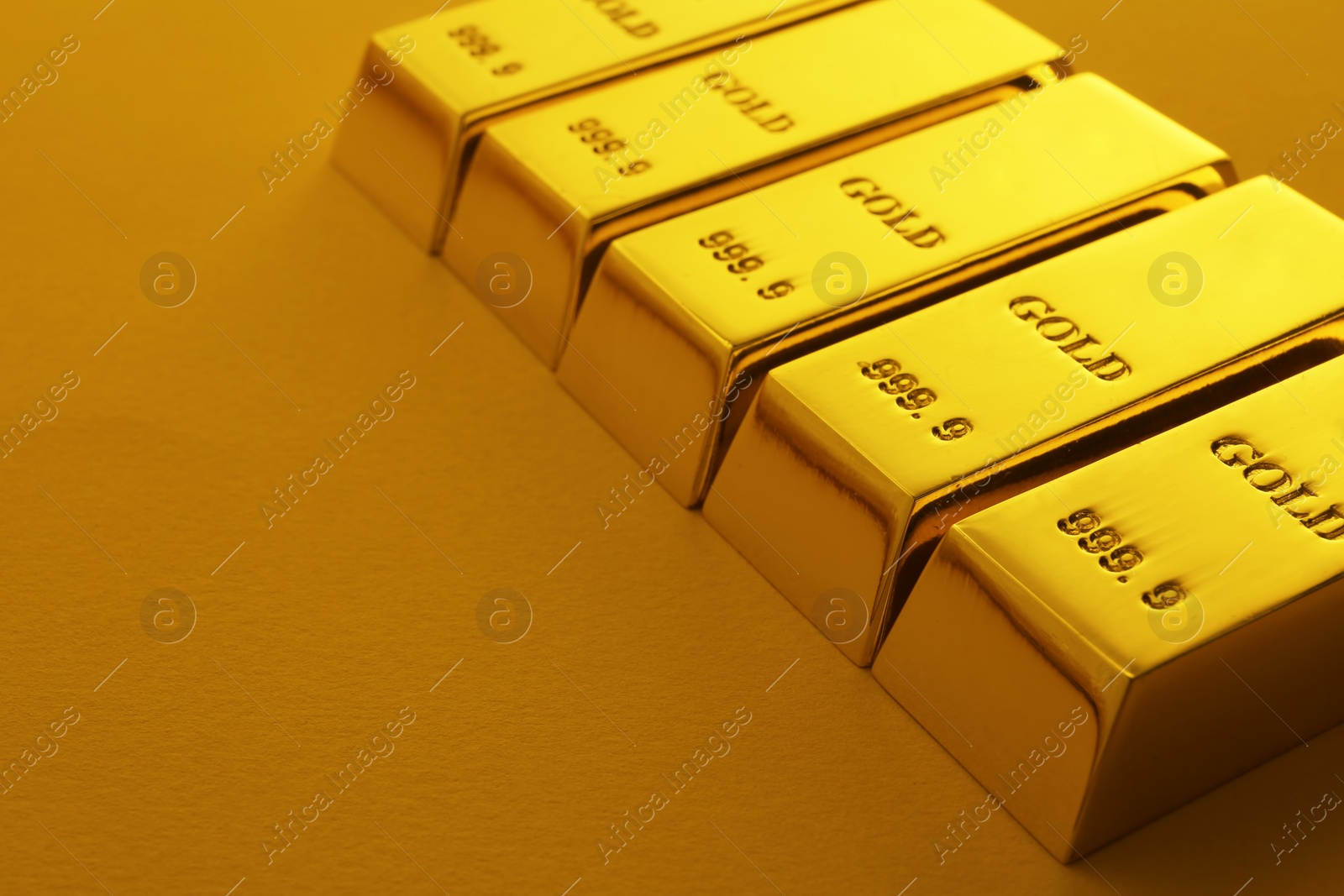 Photo of Shiny gold bars on color background. Space for text