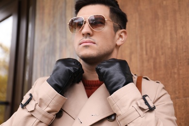 Handsome stylish man wearing black leather gloves outdoors, focus on hands