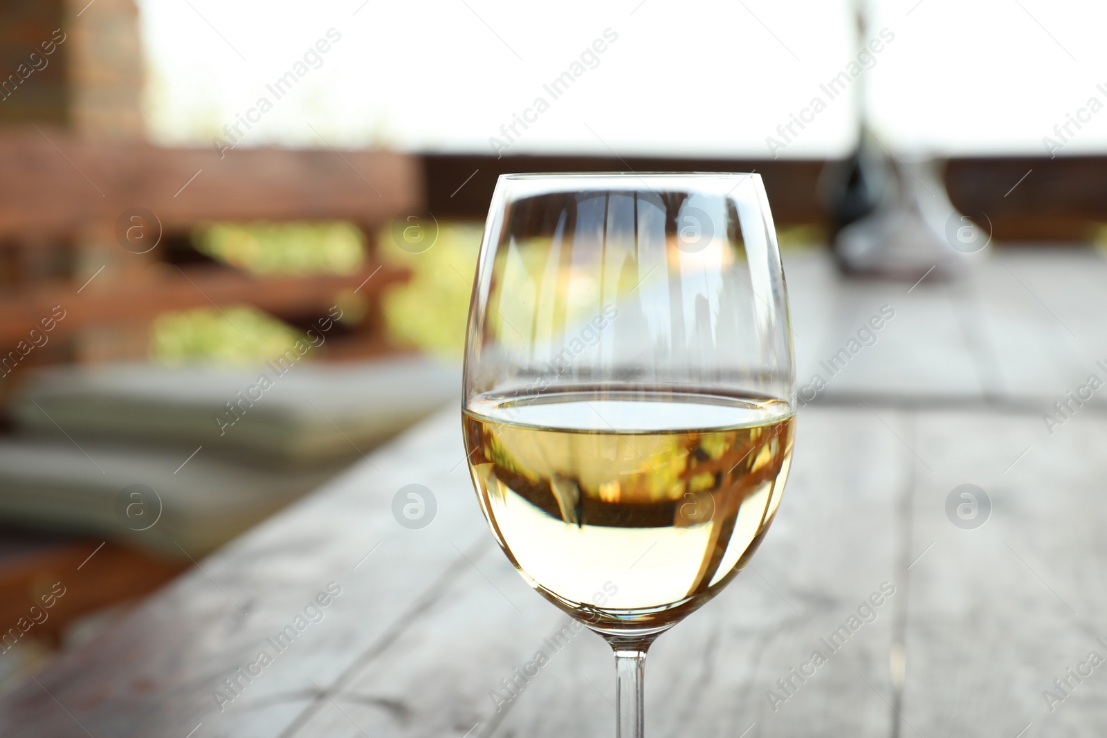 Photo of Glass of delicious white wine on blurred background, closeup. Space for text