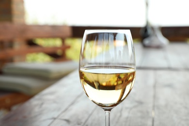 Photo of Glass of delicious white wine on blurred background, closeup. Space for text