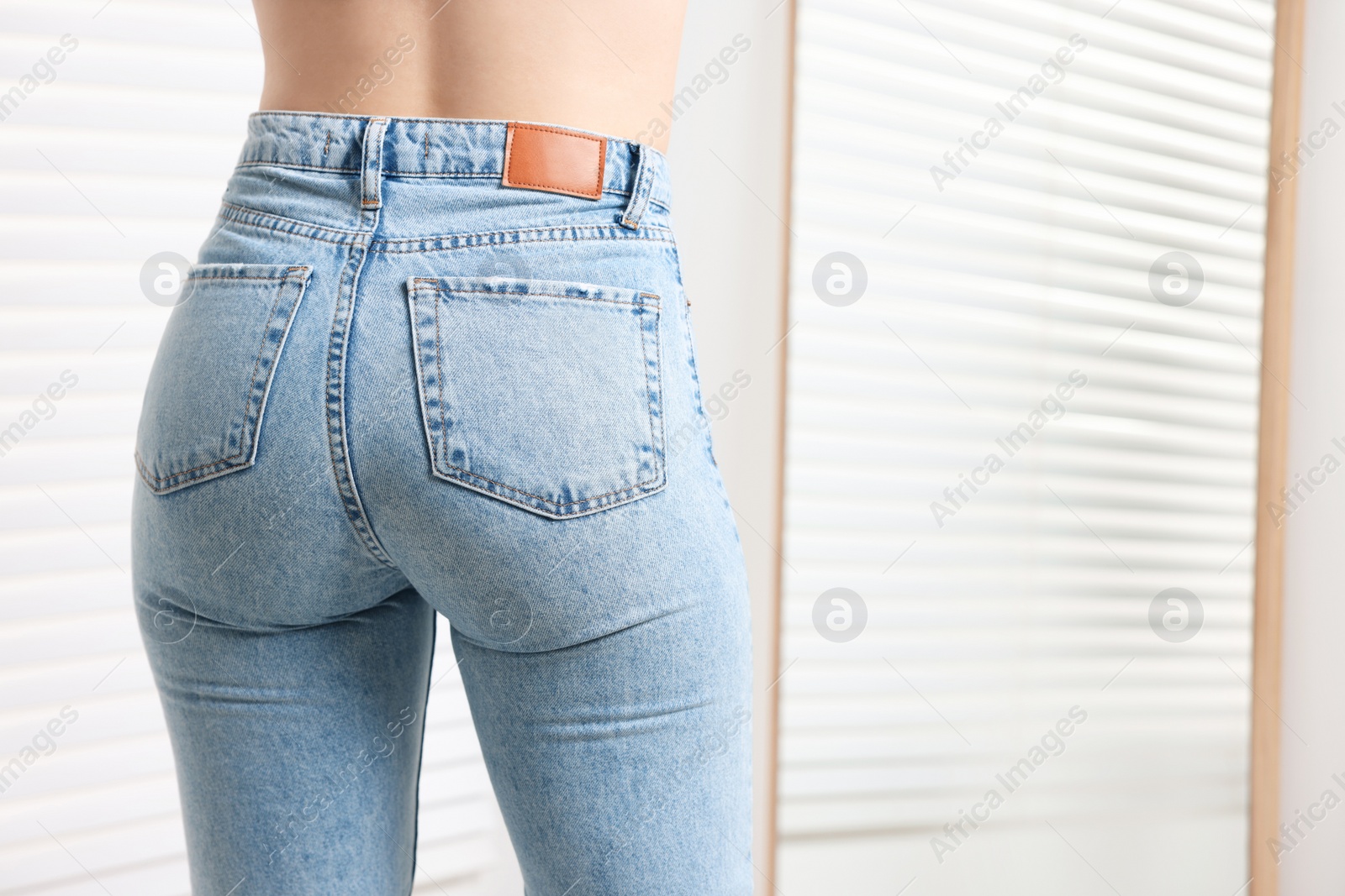 Photo of Woman in stylish jeans indoors, closeup. Space for text