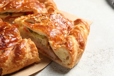 Cut delicious homemade pie on light grey table, closeup