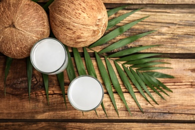Flat lay composition with glasses of coconut water on wooden background