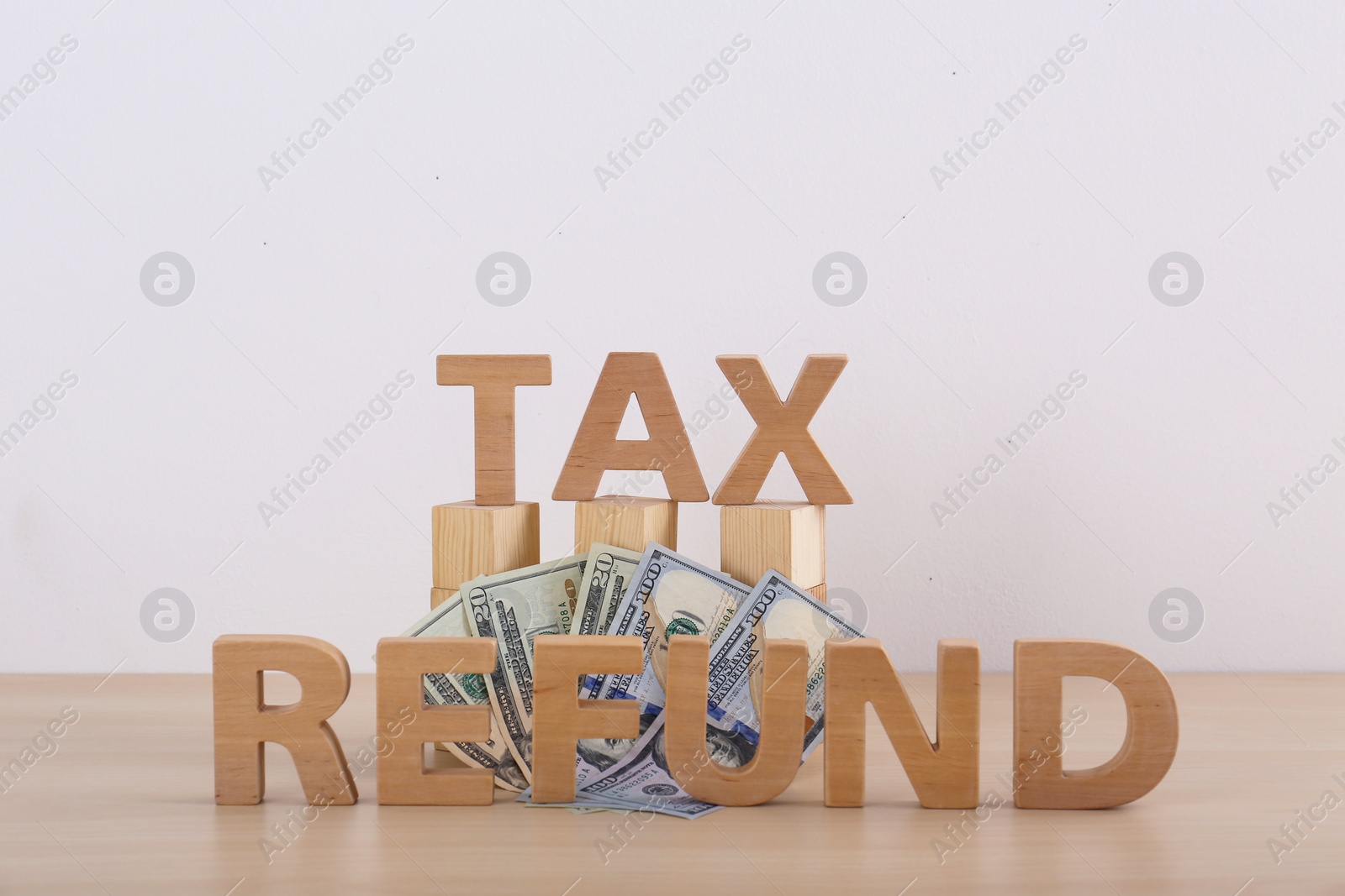 Photo of Phrase TAX REFUND and money on table