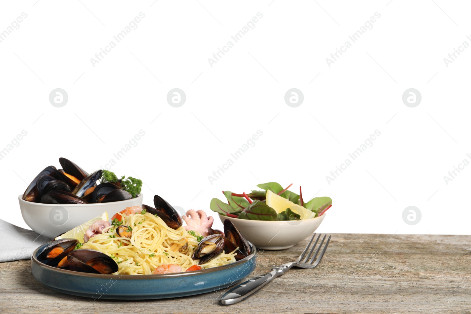 Photo of Delicious spaghetti with seafood served on wooden table against white background