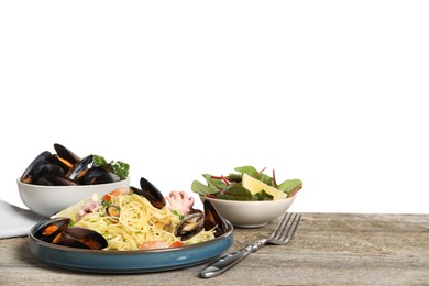 Delicious spaghetti with seafood served on wooden table against white background