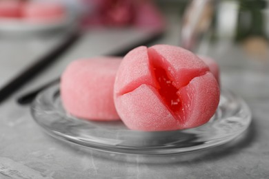 Photo of Glass plate with delicious mochi on grey table, closeup. Traditional Japanese dessert