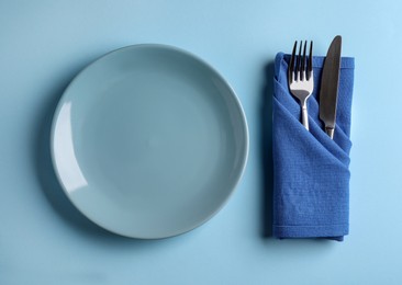 Photo of Beautiful table setting on light blue background, flat lay