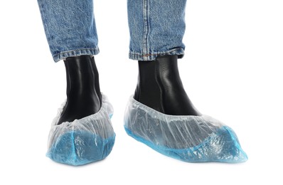 Woman wearing blue shoe covers onto her boots against white background, closeup